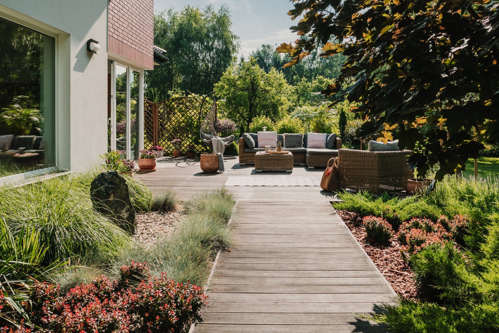 Wooden path to terrace in the garden with trendy garden furniture